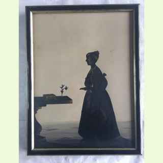 Georgian silhouetee portrait of a young girl atanding near a Georgian table decorated witn casket and vase of flowers