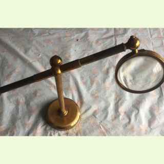Brass bullseye magnifying glass on stand.